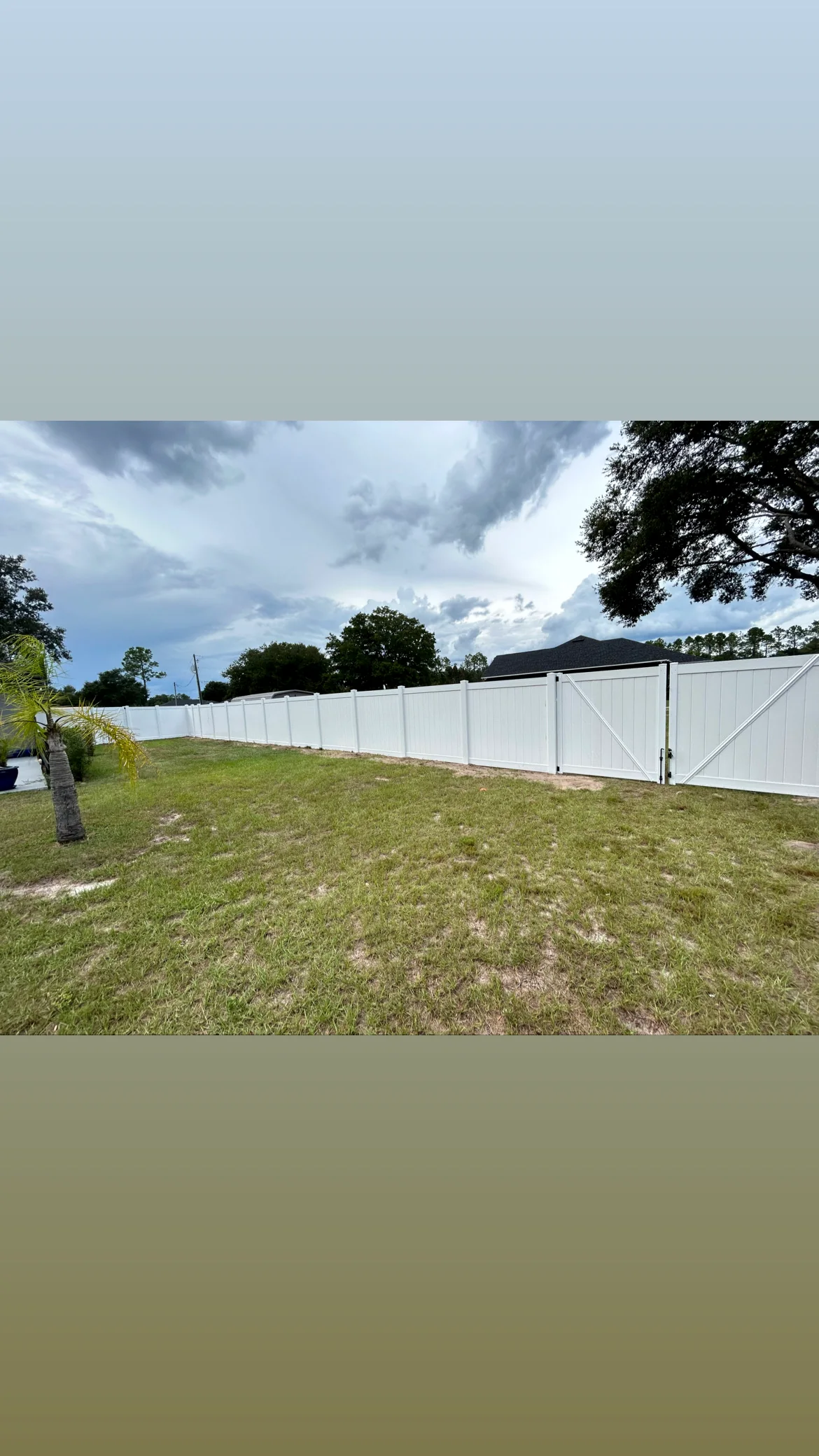 Long white vinyl privacy fence with a matching double gate