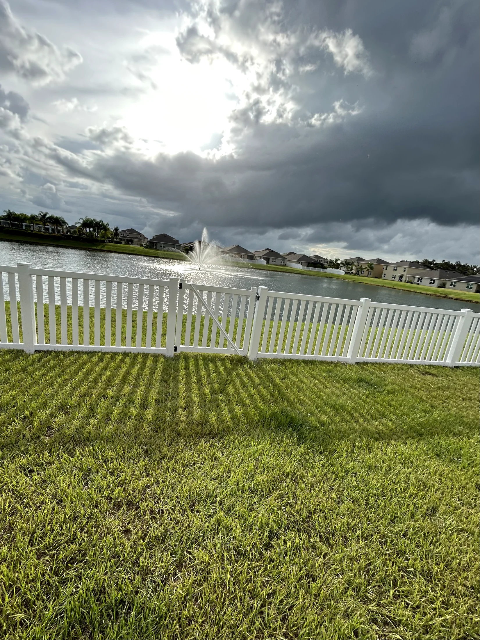 White picket fence and gate overlooking a neighborhood lake