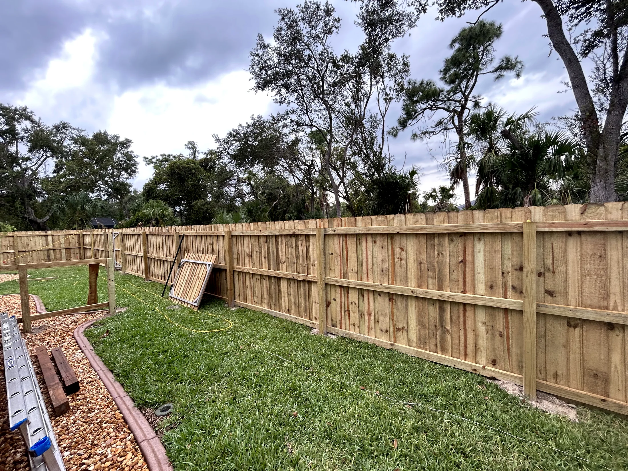 New wood privacy fence installed along a backyard property line